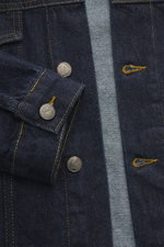 Nahaufnahme der Percival Jeansjacke "Western Trucker" navy aus reinem Baumwoll-Denim, Slim Fit, mit Knopfleiste, Umlegekragen und Brusttaschen, fotografiert von oben.