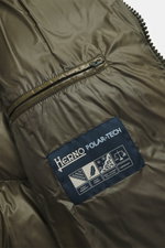 Close-up view of the Herno Down jacket olive, showing high-quality microfiber with a smooth feel, warm down filling, a zipper pocket with patch on the sleeve, soft lining fabric, and two-way zipper. The regular fit jacket features slanted hip pockets with