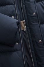 Nahaufnahme des navyfarbenen Herno Daunen-Steppmantels aus leichtgewichtiger Microfaser, mit Reißverschluss, Druckknöpfen und gebrandetem Futter, frontal fotografiert.