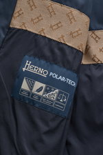 Nahaufnahme des Herno Daunen-Steppmantel navy Innenfutters mit Label, braunem Webpelzkragen, wasserabweisend, Daunenfüllung, Regular Fit, Tunnelzug-Kapuze.