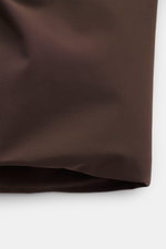 Nahaufnahme der dunkelbraunen Herno Daunenjacke im Blouson-Look mit glattem Microfasermaterial und gesteppter Daunenfüllung aus seitlicher Perspektive.