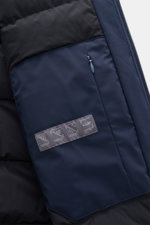 Nahaufnahme der Innenseite der Herno Daunenjacke navy, seitlich fotografiert, zeigt wasserabweisende Microfaser mit Daunenfüllung, Reißverschluss, Zipper-Fronttasche, gesteppter Futterstoff und Pflegehinweis-Label.