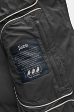 Nahaufnahme des Innenfutters vom Herno Daunen-Kurzmantel dunkelgrau mit Label, geschmeidiger Microfaser und hochwertiger Daunenfüllung.
