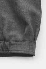 Close-up front view of the Briglia 1949 Jacket 'Bill' dark grey melange showing pure new wool fabric with slightly textured feel, slim fit, turn-down collar, two-way zipper, cuffed sleeve ends, slant welt pockets, smooth lining fabric, and one inside pock