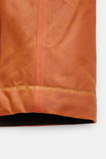 Close-up front view of the Manifattura Ceccarelli Waxed jacket 'Blazer Coat' orange, showing waxed cotton fabric with visible stitching and texture, highlighting its water repellent and breathable features. The waxed jacket 'Blazer Coat' by MANIFATTURA CE