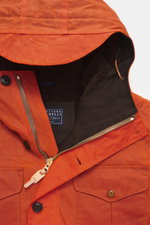 Manifattura Ceccarelli Waxed jacket 'Weekender' orange shown from a close-up top front angle, featuring waxed cotton, typical material feel, water-repellent, slim fit, light padding made of pure wool, two-way zipper, wind flap with buttons, patch chest an