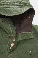 Nahaufnahme der Manifattura Ceccarelli Wachsjacke 'Weekender' oliv von schräg oben, gewachste Baumwolle, materialtypische Haptik, wasserabweisend, Slim Fit, leichte Wollwattierung, Zwei-Wege-Reißverschluss, Windblende mit Knöpfen, Brust- und Hüfttaschen m