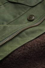 Nahaufnahme der Manifattura Ceccarelli Wachsjacke 'Weekender' oliv aus gewachster Baumwolle mit wasserabweisender, materialtypischer Haptik, Slim Fit, Zwei-Wege-Reißverschluss, Windblende mit Knöpfen, aufgesetzten Brust- und Hüfttaschen mit Patte, Ärmelab