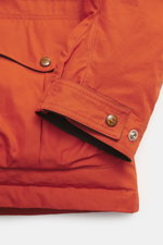 Close-up view of the sleeve and pocket detail of the Manifattura Ceccarelli Down jacket 'Fisherman' orange, pure cotton, soft touch, regular fit, warm down filling, two-way zipper, wind flap with press studs, high-closing collar with hood, raglan sleeves,