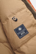 Close-up inside view of the Manifattura Ceccarelli Down jacket 'Fisherman' orange, showing pure cotton beige fabric, quilted lining, button detail, and brand label, photographed from a top side angle. Features include soft touch, regular fit, warm down fi