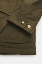 Close-up view of the sleeve and pocket details of the Manifattura Ceccarelli Down jacket 'Fisherman' olive, showing pure cotton fabric, soft touch, regular fit, warm down filling, two-way zipper, wind flap with press studs, high-closing collar with hood, 
