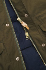 Close-up front view of the Manifattura Ceccarelli Down jacket 'Fisherman' olive showcasing the two-way zipper with leather pull, wind flap with press studs, and slanted front pocket flap. Made of pure cotton with a soft touch, this regular fit jacket feat