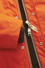 Nahaufnahme der Manifattura Ceccarelli Jacke 'Shelter' orange mit Slim Fit, robuster Zwei-Wege-Reißverschluss, Windblende mit Druckknöpfen, Stehkragen, regulierbarer Kapuze, paspelierten Taschen, Windschutzbündchen, verstellbarem Saum, supersoftem Wollfut