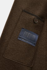 Close-up, angled view of Harris Wharf London Wool jacket dark brown showing textured felted virgin wool fabric, buttoned breast pocket, and label.

Description: <p>Casual and cosy: This cropped wool jacket by HARRIS WHARF LONDON, made of felted virgin woo