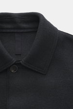 Close-up front top view of Harris Wharf London Wool jacket dark navy, knitted and felted virgin wool, heavy sturdy quality, raw-edge finish, slim fit, four-button placket, turn-down collar, patch pockets, unconstructed design.