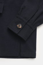 Close-up of the sleeve and hem of the Doppiaa Jacket 'Aaliante' navy, photographed from above, showing wool blend, soft feel, regular fit, concealed five-button placket, turn-down collar, patch pockets with flap, sleeve cuffs with cuff, back yoke with pin