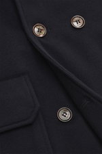 Nahaufnahme der dunkelbraunen Moorer Cashmere Cabanjacke 'Bas' mit Knöpfen, Tasche und feiner Daunenfüllung, von schräg oben fotografiert.