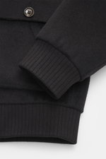Nahaufnahme des Gimo's Blouson dark navy von oben auf Ärmel mit flexiblem Rippbündchen, Schurwollmix, Steppfutter, Lammfellbesatz und Metallknopf.