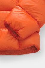 Nahaufnahme der rechten Ärmelmanschette der Polo Ralph Lauren Daunenjacke orange, hochwertig aus Microfaser mit glattem Griff, wärmender Daunenfüllung, Slim Fit, elastischem Abschluss, Ton-in-Ton Futterstoff und Logo Stitching, fotografiert aus seitlicher