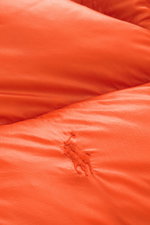 Nahaufnahme der orangen Polo Ralph Lauren Daunenjacke mit hochwertiger Microfaser, glattem Griff, Slim Fit und tonalem Logo Stitching, Detailansicht.