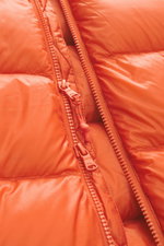 Nahaufnahme der Polo Ralph Lauren Daunenjacke orange mit hochwertiger Microfaser, glattem Griff, wärmender Daunenfüllung, Slim Fit, kragenhohem Reißverschluss, Kapuze mit Tunnelzug, Zipper-Fronttaschen, elastischen Ärmelabschlüssen, tonalem Logo Stitching