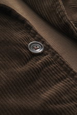 Detailaufnahme aus schräger Nahperspektive der Polo Ralph Lauren Cordjacke 'Finley' dunkelbraun mit weichem Baumwollcord, Knopf und feiner Struktur.