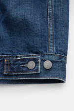 Nahaufnahme der Ärmelmanschette der Polo Ralph Lauren Jeansjacke rauchblau, Slim Fit, Denim aus reiner Baumwolle, leicht griffig, Nähte in Kontrastfarbe, regulierbare Knopfriegel am Saum.