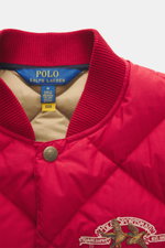 Polo Ralph Lauren Down Blouson Red shown from a close-up front view, featuring a red quilted fabric, ribbed knit blouson collar, snap button placket with branded button, and embroidered chest stitching. <p>Preppy through the cold season: this quilted blou