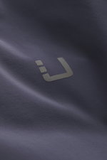 Close-up front view of UBR Down jacket 'Phantom' dark blue showing reflective UBR logo on elastic microfiber, water-repellent fabric with light down filling, slim fit, two-way zipper, high-closing stand-up collar, practical hood, zipper front pockets, smo
