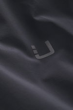 Close-up front view of the UBR Down jacket 'Phantom' dark navy showing reflective UBR logo on elastic microfiber, water-repellent fabric.
