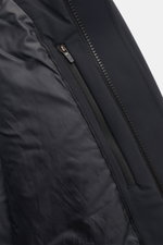 Close-up view of the inside zip pocket and front zipper of the UBR Short coat 'Regulator Coat' black, highlighting smooth, waterproof fabric. The model 'Regulator Coat' by Norwegian label UBR is lightweight and functional with Scandinavian simplicity, the