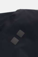 Close-up view of the UBR Short coat 'Regulator Coat' black showing the smooth, high-quality microfiber fabric and reflective chest logo, highlighting Scandinavian simplicity and functional design.