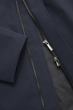 Nahaufnahme des Reißverschlusses und Materials vom dunkelblauen UBR Kurzmantel 'Regulator Coat' mit glattem Griff, bi-elastischer Microfaser und wasserfester Membran.