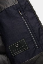 Close-up view from above of the UBR Down jacket 'Concord' navy melange showing the zippered front pocket, smooth lining, and Savile label. Urban style meets high performance: The 'Concord' down jacket from UBR combines innovative functionality with modern