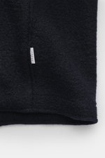 Nahaufnahme der Struktur und des kleinen weißen Weblabels der 04651/ A trip in a bag Wolljacke 'Boiled Blouson' navy aus Bouclé-Strick, reine Schurwolle, gewalkte Qualität, weicher Griff, Raw-Edge-Finish, Slim Fit, Metall-Reißverschluss, Umlegekragen, sch