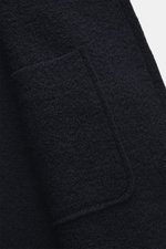 04651/ A trip in a bag Wolljacke 'Boiled Blouson' navy, Detailaufnahme aus seitlicher Nahaufnahme, Bouclé-Strick, gewalkte Qualität, weicher Griff, Raw-Edge-Finish, Slim Fit, Metall-Reißverschluss, Umlegekragen, schräge Leistentaschen, kleines Weblabel, Ä