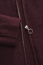 Nahaufnahme aus schräger Perspektive der 04651/ A trip in a bag Wolljacke 'Boiled Blouson' bordeaux mit Bouclé-Strick aus reiner Schurwolle, gewalkter Qualität, weichem Griff, Raw-Edge-Finish, Slim Fit, Metall-Reißverschluss mit rundem Zipper, Umlegekrage