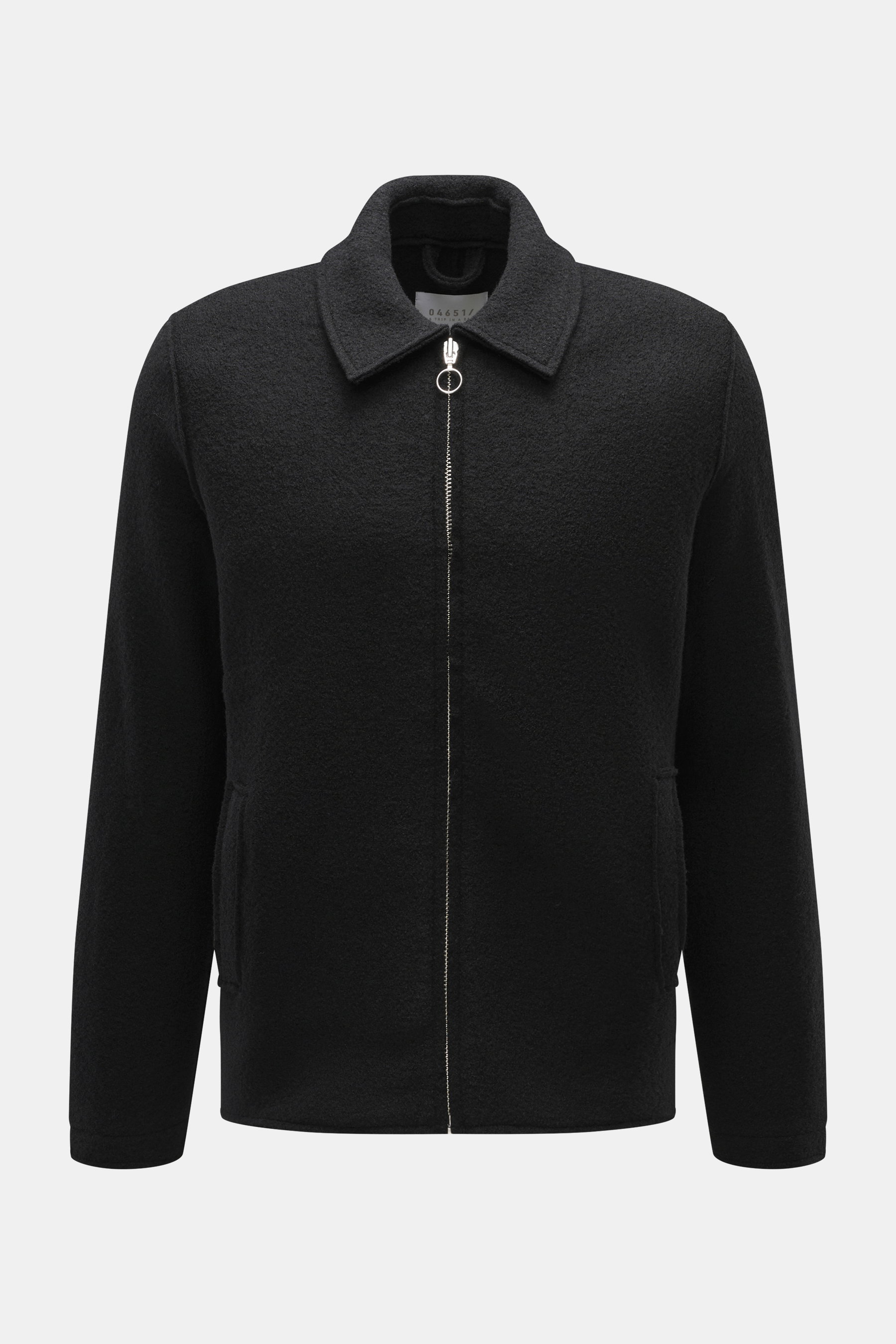 Frontale Nahaufnahme der 04651/ A trip in a bag Wolljacke 'Boiled Blouson' schwarz aus Bouclé-Strick reiner Schurwolle, Slim Fit, gewalkt mit Metall-Reißverschluss, Umlegekragen, schräge Leistentaschen, Raw-Edge-Finish, Druckknopf-Ärmelabschlüssen, Uncons