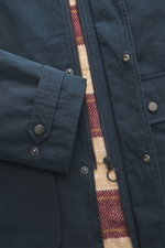 Nahaufnahme der 04651/ A trip in a bag Wachsjacke 'Sailor' navy/braun, Detailansicht von Reißverschluss, Druckknöpfen und Flanellfutter.