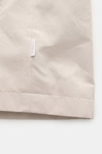 04651/ A trip in a bag Wachsjacke 'Sailor' sand/braun Nahaufnahme aus seitlicher Perspektive zeigt gewachste Baumwolle mit Label, winddicht, Slim Fit, Cordkragen.