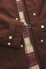 Braune 04651/ A trip in a bag Wachsjacke 'Sailor' aus gewachster Baumwolle, Nahaufnahme von Reißverschluss, Druckknöpfen und kariertem Flanellfutter.