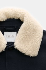 Close-up front view of the 04651/ A trip in a bag Jacket 'Double Blouson' navy showing the soft wool blend fabric and plush lambskin trim on the turn-down collar, featuring a four-button placket and label inside. Eyecatcher for the transitional season: Th