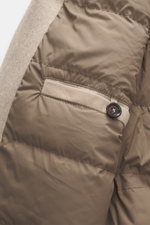 Nahaufnahme des Innenfutters des Eddy Monetti Cashmere Daunenblouson 'Teos' beige, mit glattem, gesteppter Stoff, Lederpaspel und Knopf.