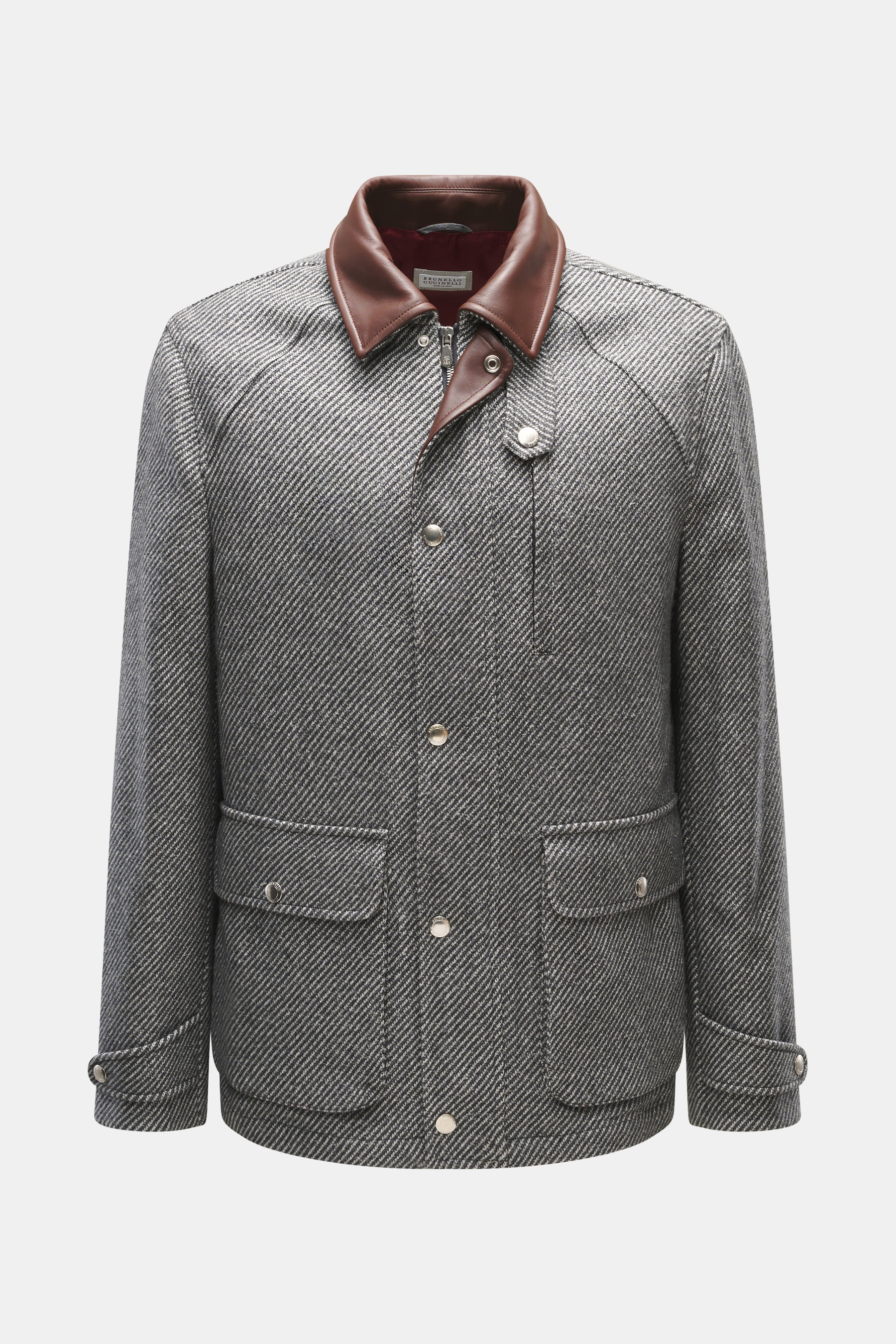 Front view of a Brunello Cucinelli Jacke grau, a slim-fit grey jacket with brown leather collar, chest and front flap pockets, button cuffs, and adjustable waist tabs. Made from a mix of cashmere and virgin wool with a removable Thermore-padded liner for 