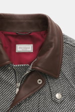 Close-up front view of Brunello Cucinelli Jacke grau featuring a brown leather collar, red inner lining, silver zipper, and grey herringbone wool-cashmere fabric.

Description incorporating the provided content:

<p>Klassische Eleganz mit Utility-Elem