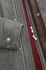 Close-up front view of the Brunello Cucinelli Jacke grau showing grey herringbone cashmere and wool fabric, silver snaps, zipper, and brown leather trim.

Description: <p>Klassische Eleganz mit Utility-Elementen von BRUNELLO CUCINELLI: Die Jacke mit den
