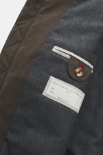 Nahaufnahme des Innenteils vom Brunello Cucinelli Blouson graubraun, Blick auf Label, Knopf und Stoffmix aus Baumwolle und Microfaser.