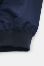 Brunello Cucinelli Blouson dunkelblau, Detailaufnahme des elastischen Bündchens aus hochwertiger Microfaser mit glattem Griff und leichter Wattierung.