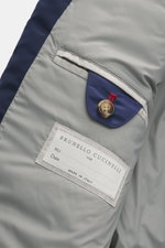 Nahaufnahme des Innenfutters vom Brunello Cucinelli Blouson dunkelblau mit weicher Microfaser, Innentasche mit Knopf und Label, glatter Griff.