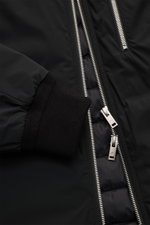 Close-up front view of the Moose Knuckles Down jacket 'Northdale' black showing zipper, ribbed cuff, and smooth microfiber fabric, sporty hoodie design, slim fit, wind- and water-repellent, light down filling, two-way zipper, hood with drawstring, zippere